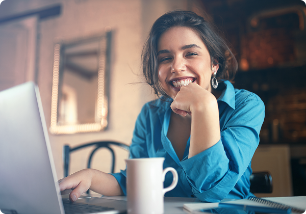 Colaboradora sorrindo enquanto trabalha no notebook